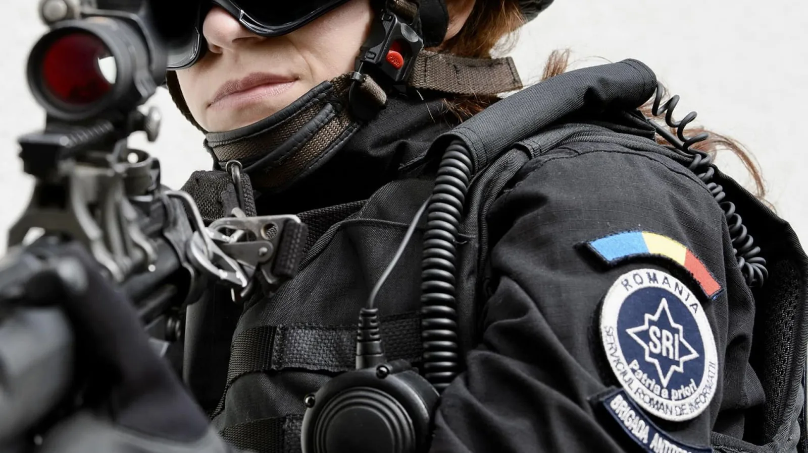 Agent SRI în echipament de intervenție, pregătit pentru acțiune de securitate.