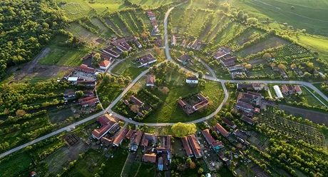 Vedere aeriană a unui sat românesc înconjurat de natură.