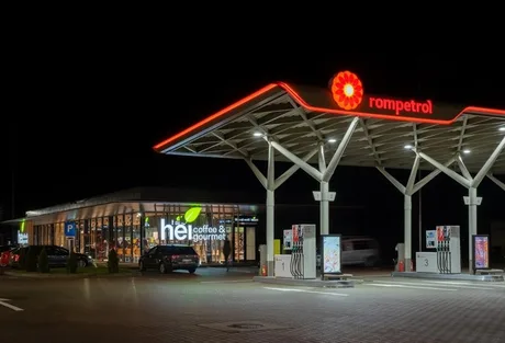 Stație Rompetrol iluminată noaptea, cu prețuri reduse la carburanți.