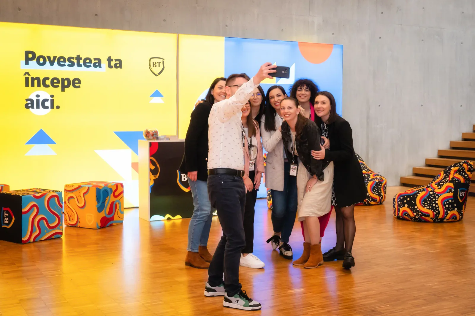 Angajați Banca Transilvania fac selfie într-un mediu de lucru modern și creativ.