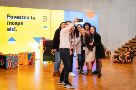 Angajați Banca Transilvania fac selfie într-un mediu de lucru modern și creativ.