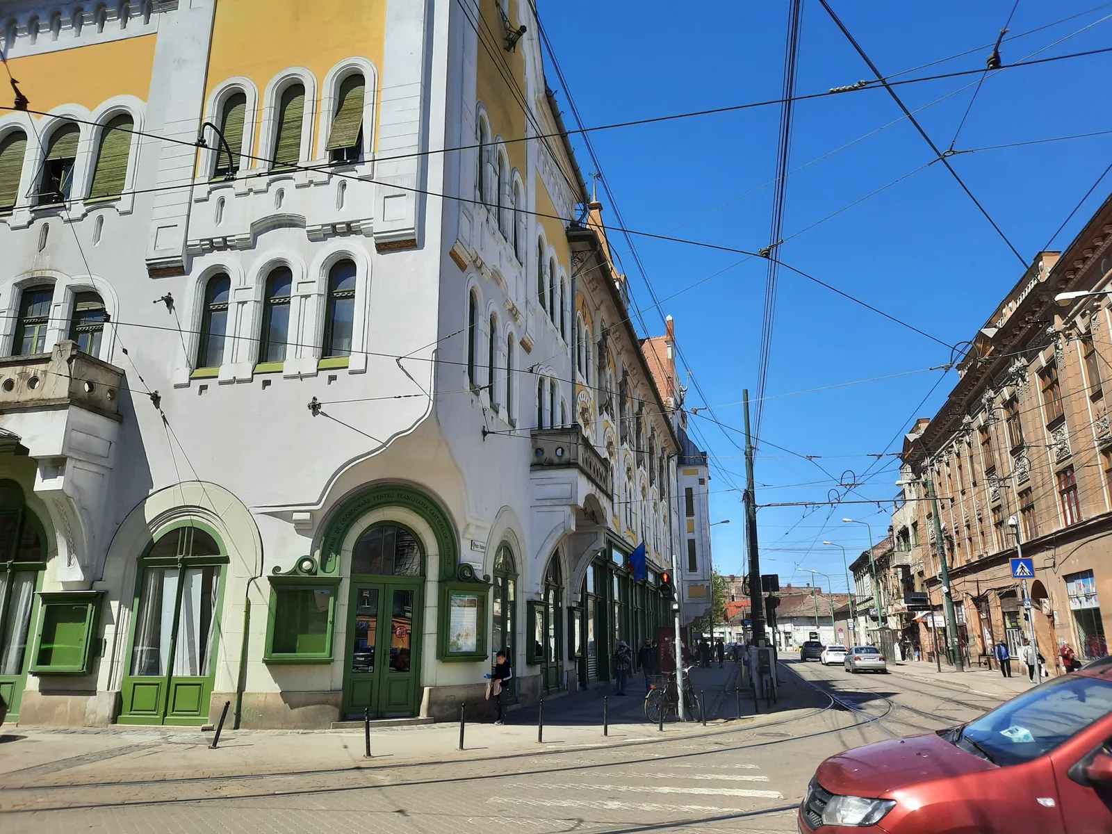 Clădiri vechi pe o stradă dintr-un oraș, sub cerul senin.