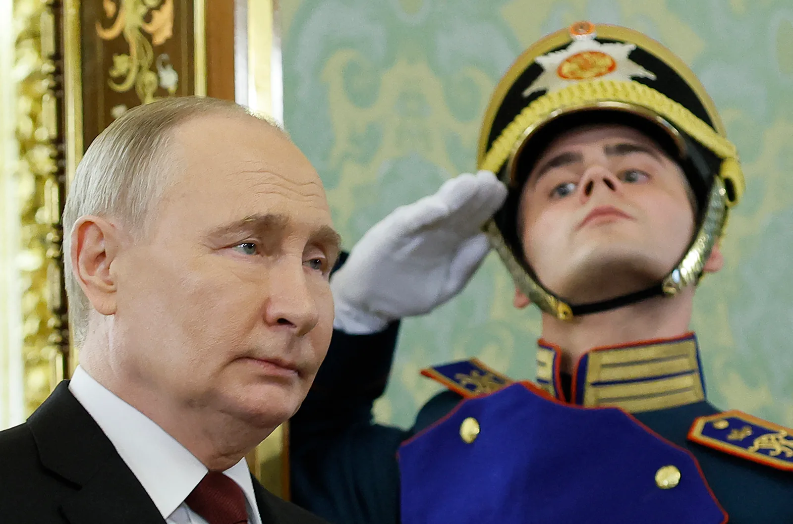 Vladimir Putin și un gardian în uniformă, într-un cadru oficial.