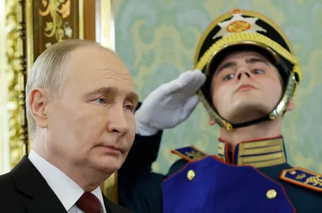 Vladimir Putin și un gardian în uniformă, într-un cadru oficial.