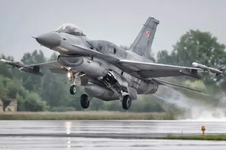 Avion de luptă polonez decolând pe un aeroport umed.