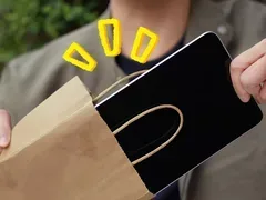 Un utilizator scoate o tabletă dintr-un sac de hârtie.