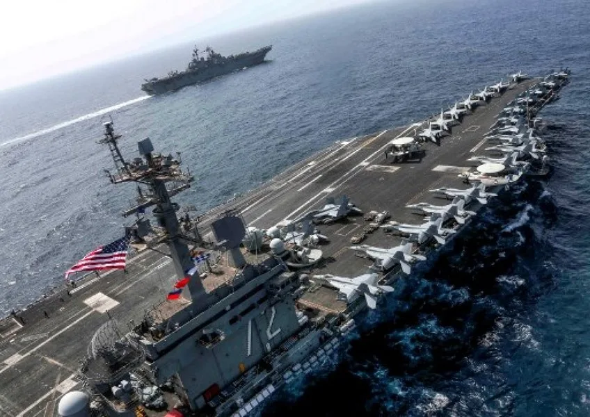 Portavionul USS Abraham Lincoln navighează pe mare, cu avioane aliniate pe punte.