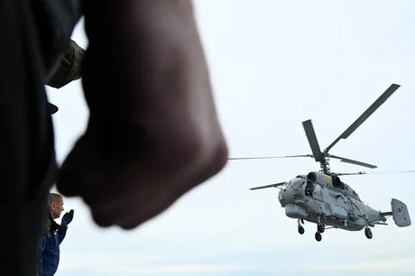 Elicopter rusesc în zbor, cu fundal de cer senin.