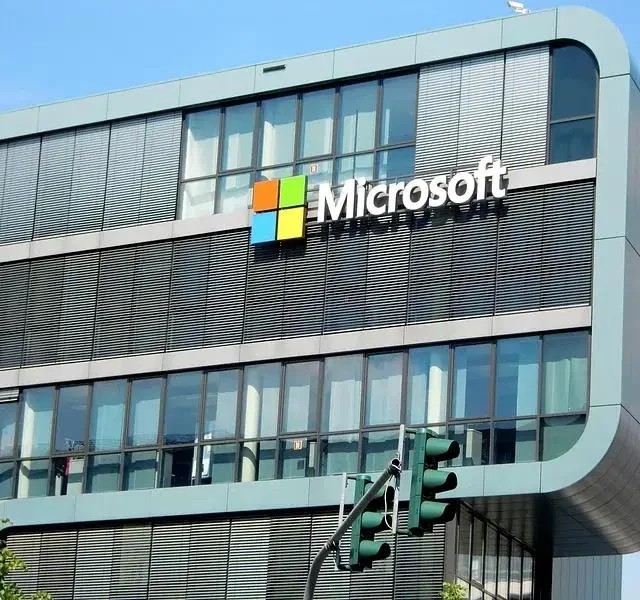 Clădirea Microsoft cu logo-ul companiei pe fațadă, sub un cer senin.