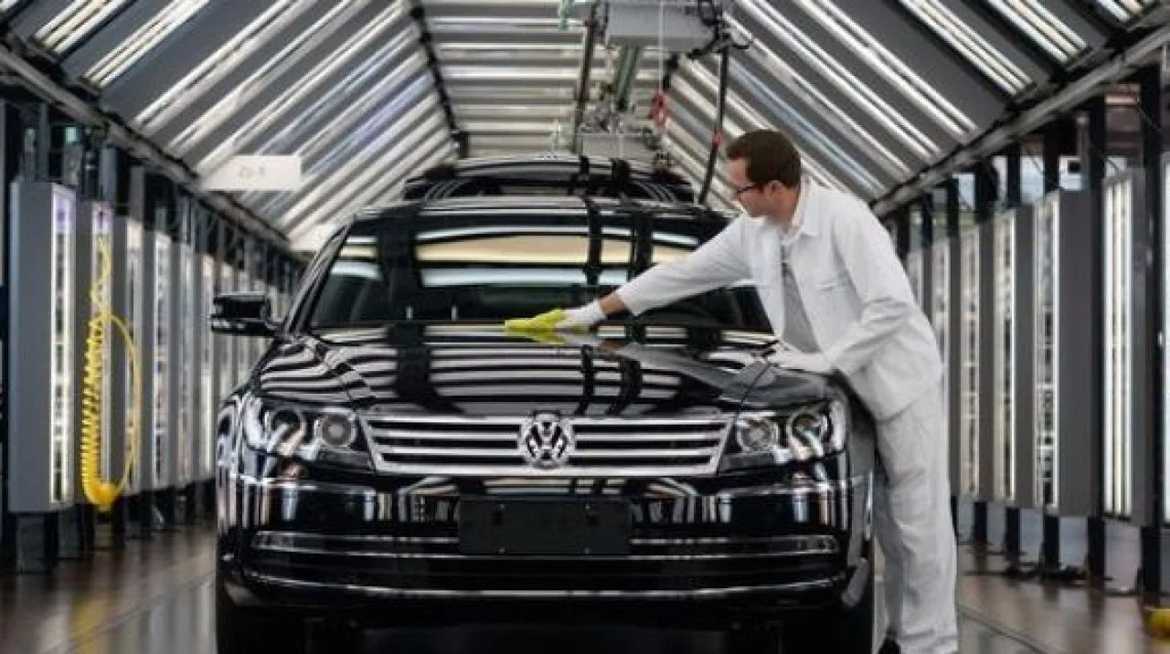 Un angajat curăță un automobil Volkswagen într-o fabrică modernă.