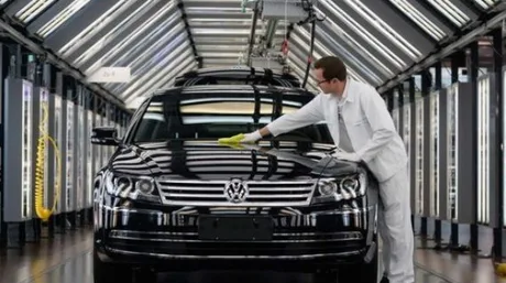 Un angajat curăță un automobil Volkswagen într-o fabrică modernă.