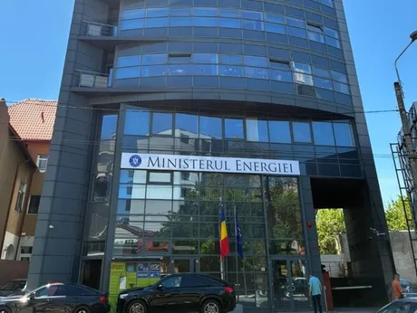 Clădirea Ministerului Energiei din România, cu steaguri și feronerie modernă.