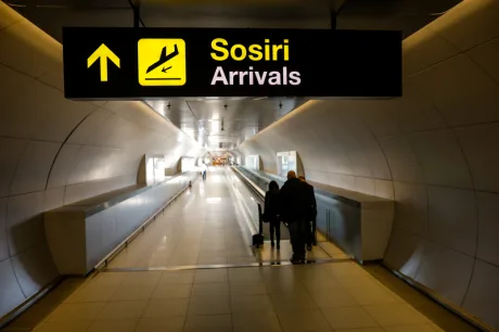 Pasageri îndreptându-se spre zona de sosiri a aeroportului.
