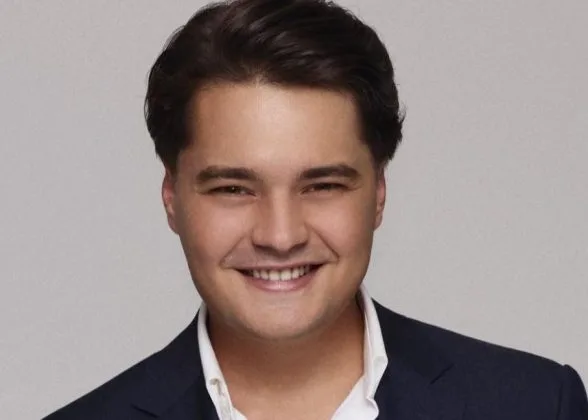 Andrei Șelaru, antreprenor român, zâmbind în costum elegant.