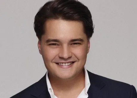 Andrei Șelaru, antreprenor român, zâmbind în costum elegant.
