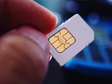Cartelă SIM ținută în mână, simbolizând funcționalități dual-SIM pe Android.