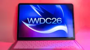 Laptop Apple cu logo WWDC26 pe ecran, iluminat în culori vibrante.