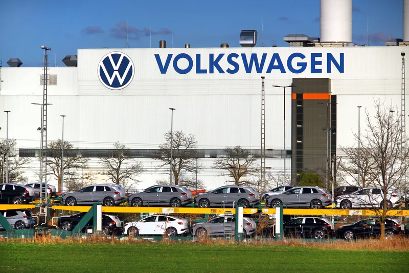 Uzina Volkswagen cu mașini parcate, în contextul restructurării și concedierilor.