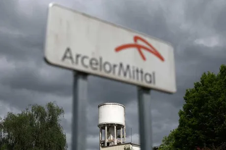 Semn ArcelorMittal pe fundalul unui cer întunecat, simbolizând dificultăți.