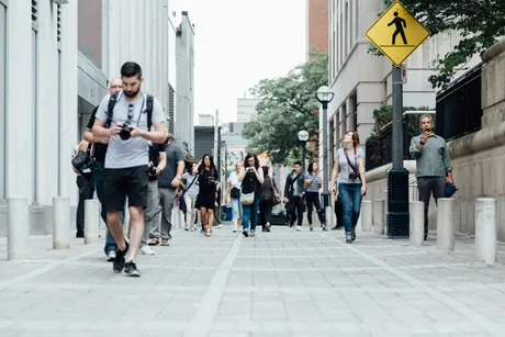 Oameni care se plimbă pe o stradă urbană aglomerată.
