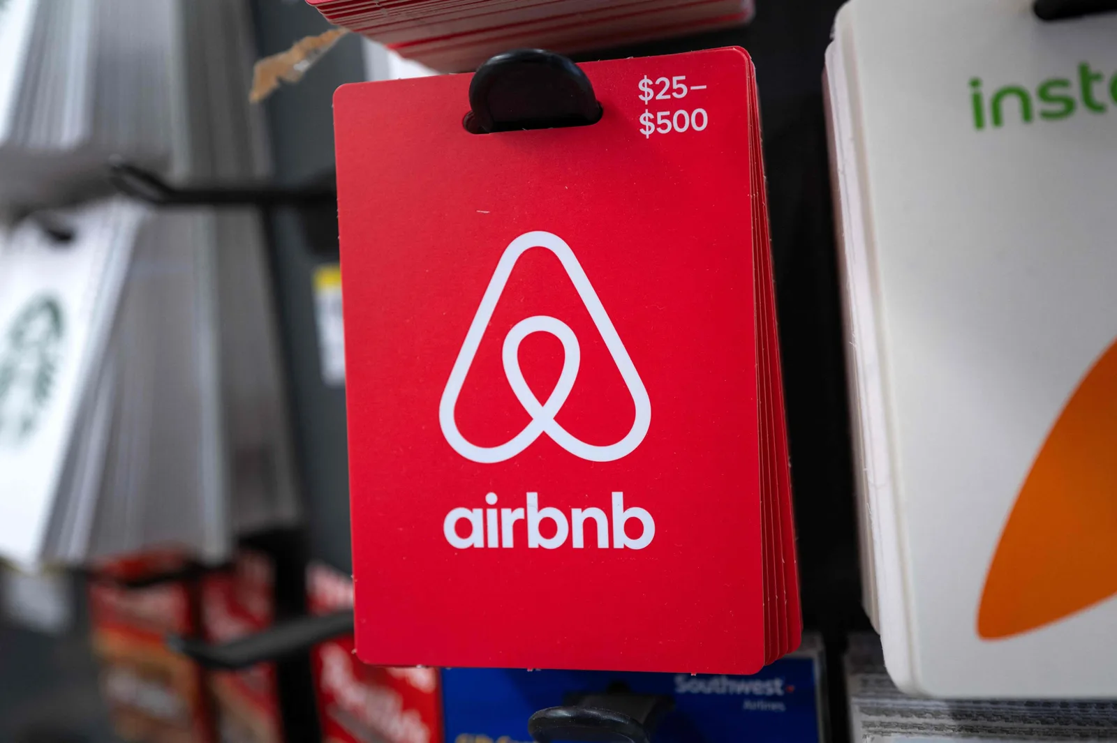 Logo-ul Airbnb pe un card de plată, expus într-un magazin.
