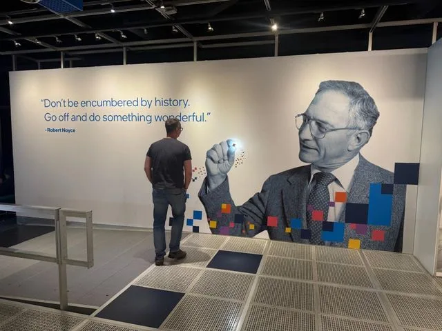 Un bărbat admiră un mural cu un citat inspirațional pe un perete.