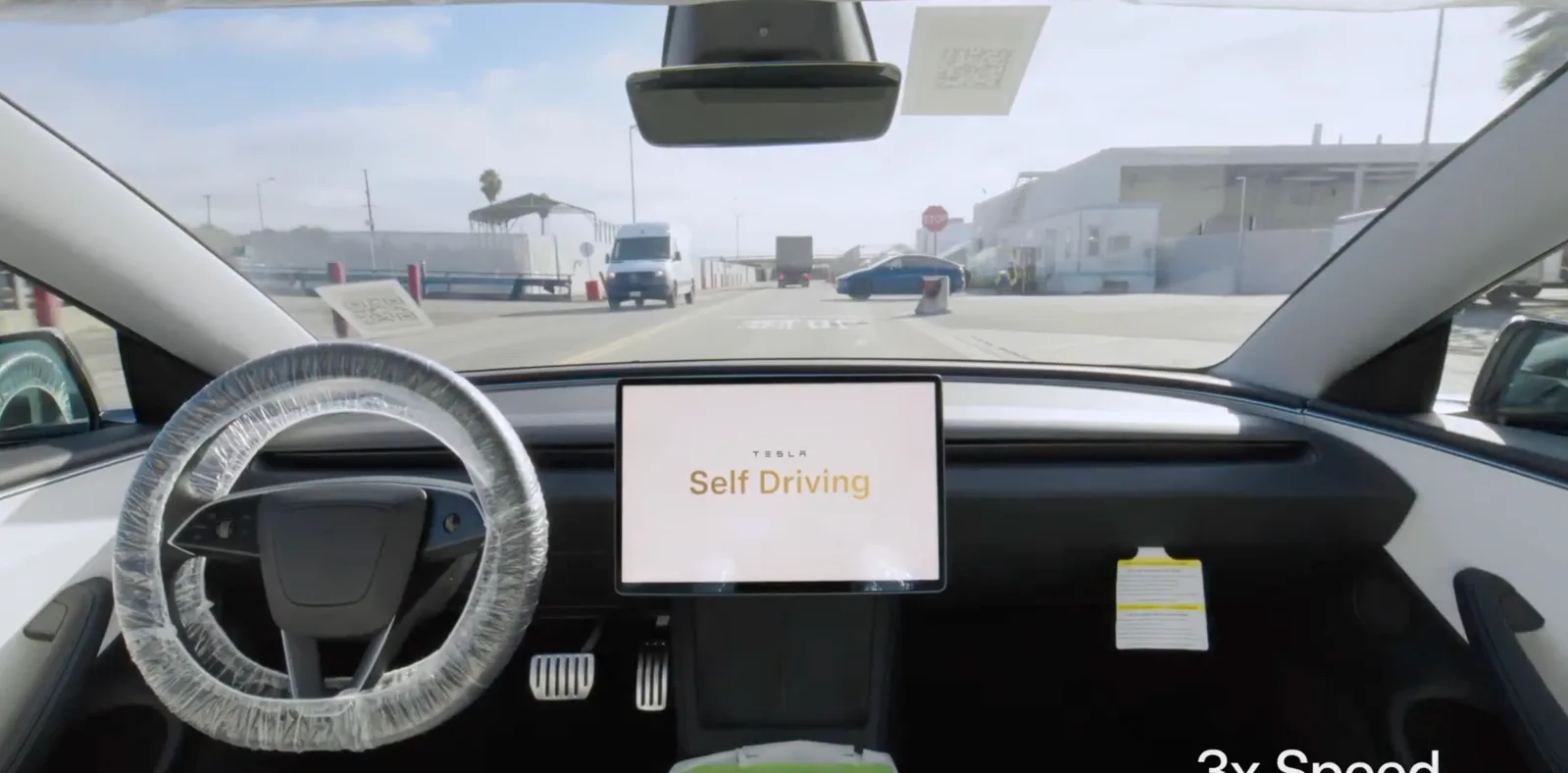 Interiorul unei mașini Tesla cu ecranul de control activat pentru conducere asistată.
