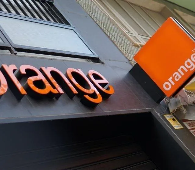 Logo-ul Orange România pe un fond urban, simbolizând schimbări în companie.