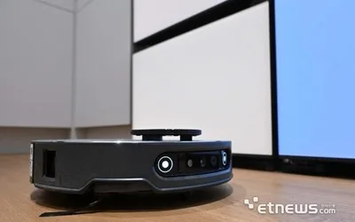 Roboți de curățenie Samsung și LG pe o masă, pregătiți pentru lansare.