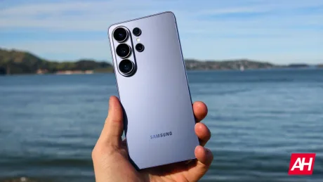 Un smartphone Samsung în mână, pe fundal de apă și cer senin.