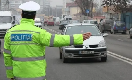 Polițist dirijând traficul pe o stradă aglomerată din oraș.
