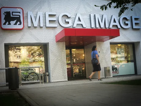 Intrarea unui magazin Mega Image din România, cu logo vizibil.