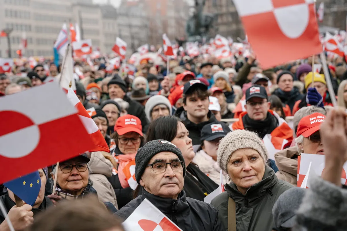 Oameni la protest cu steaguri ale Groenlandei și Uniunii Europene.