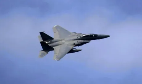 Avion militar american zburând deasupra norilor în timpul unei misiuni.