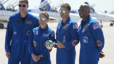 Astronauți pregătiți pentru misiuni în spațiu, discutând despre provocările microgravitației.