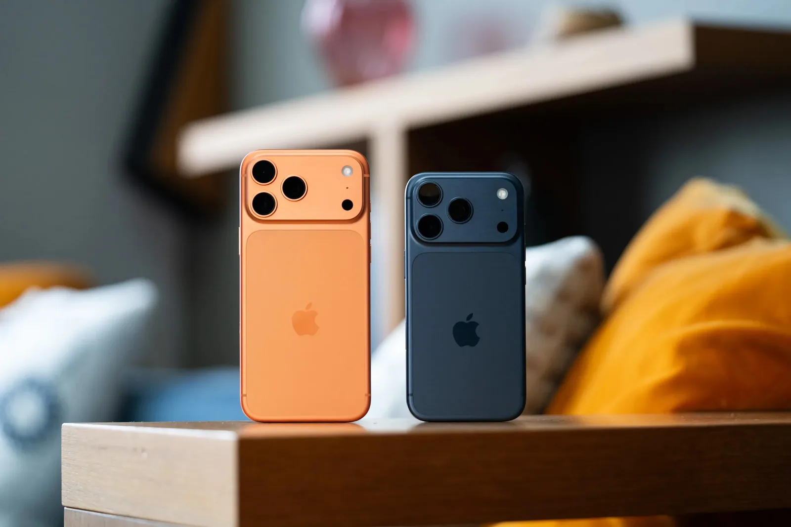 Două modele de telefoane Apple pe o masă de lemn.