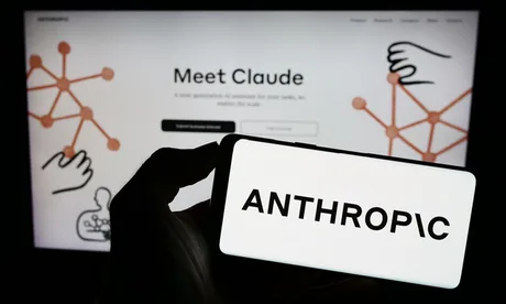 Logo-ul Anthropic pe un ecran, cu mâna care ține un telefon.