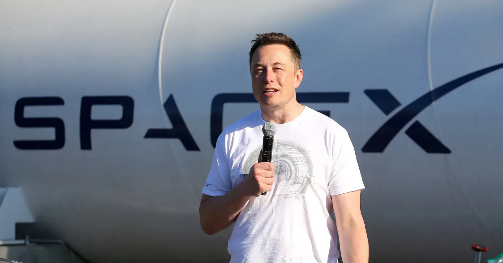 Elon Musk discutând despre SpaceX, cu un microfon în mână.
