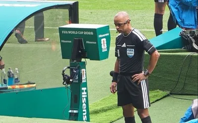 Arbitru analizând o decizie VAR la Cupa Mondială 2026.
