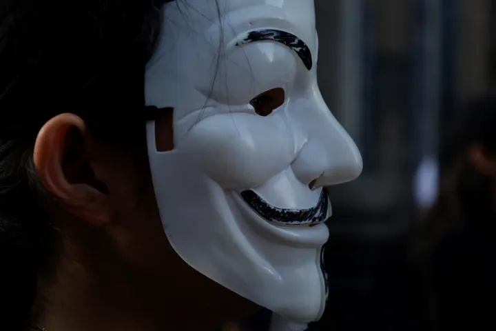 Masca simbolică a unui hacktivist, reprezentând anonimatul și protestul.