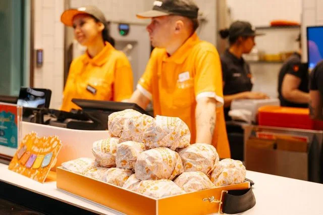 Angajați Popeyes pregătind comenzi într-un restaurant modern.
