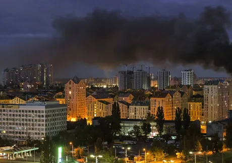 Orașul Kiev sub alertă, cu fum deasupra clădirilor în timpul nopții.