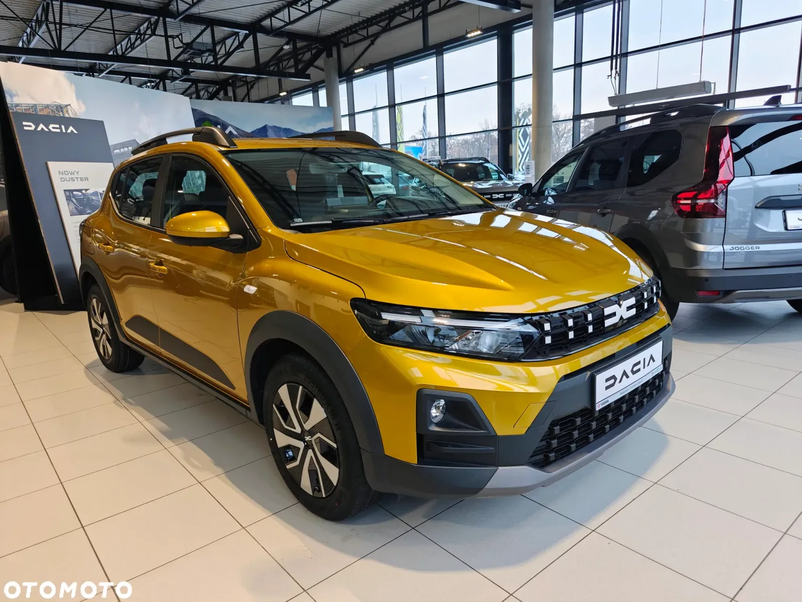 Dacia Bigster expusă într-un showroom modern, evidențiind designul său atractiv.