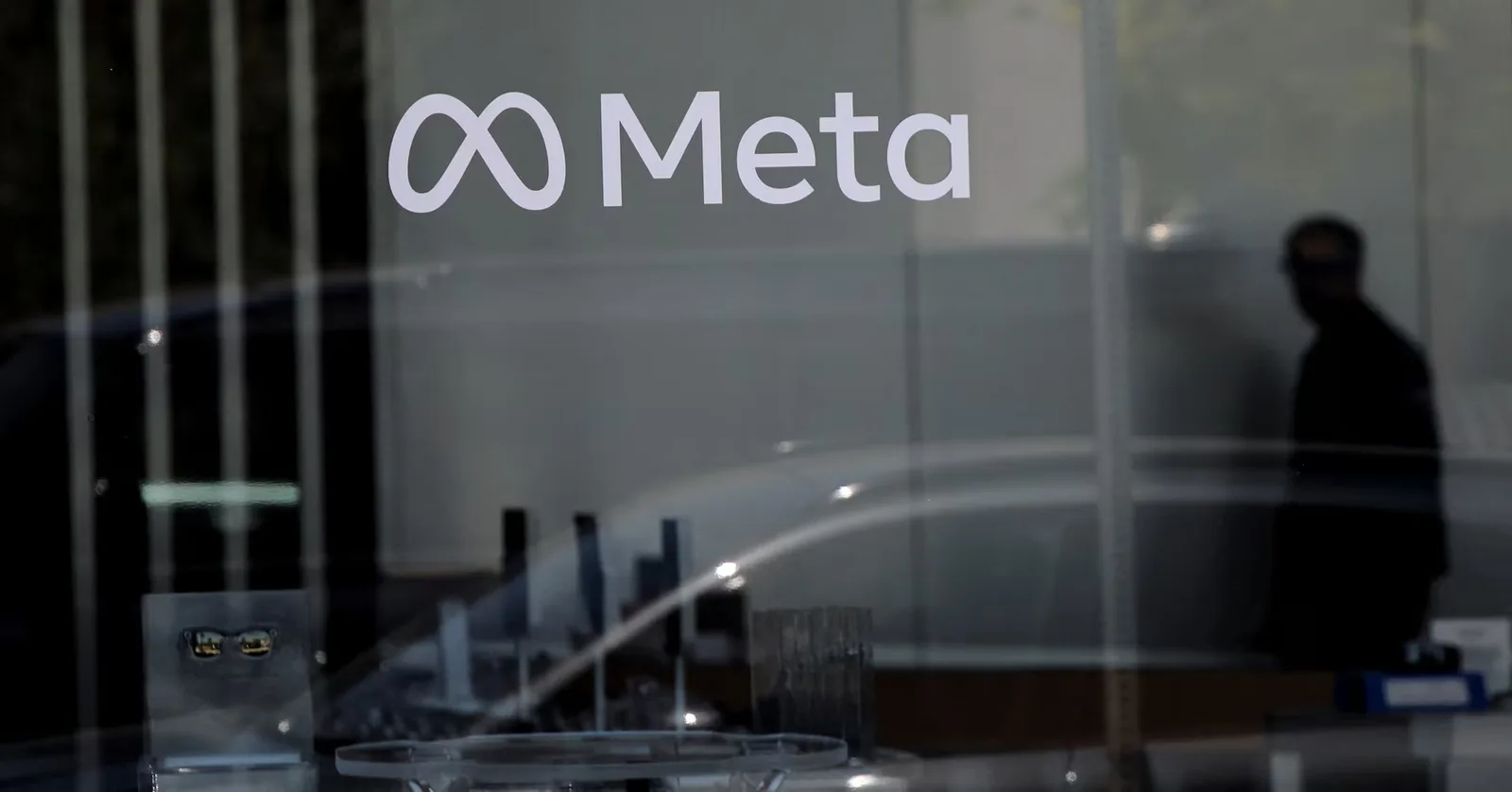 Logo Meta pe un geam, reflectând lumina din exterior.