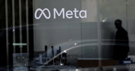Logo Meta pe un geam, reflectând lumina din exterior.