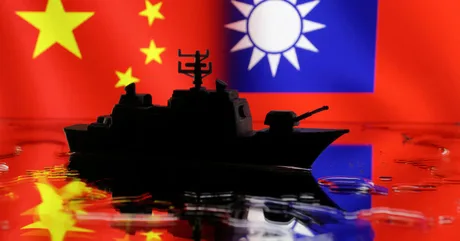 Nava de coastă pe fundalul steagurilor Chinei și Taiwanului.