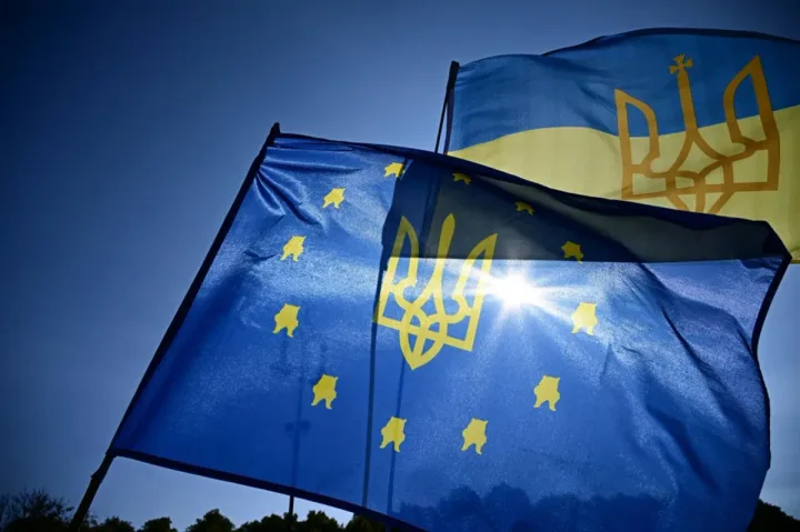 Steagurile Uniunii Europene și Ucrainei fluturând în soare.
