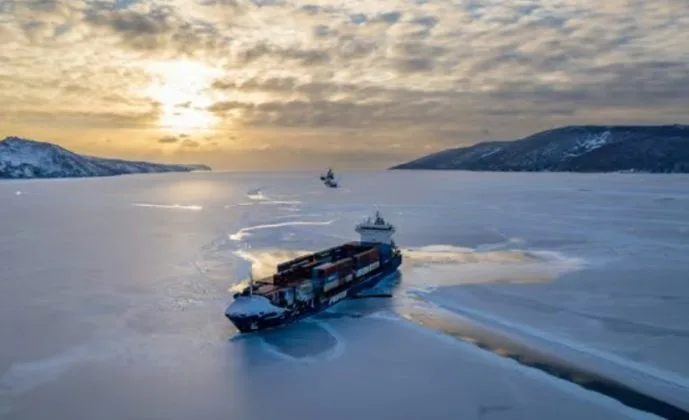 Nava de transport containere navighează pe o rută maritimă acoperită de gheață.