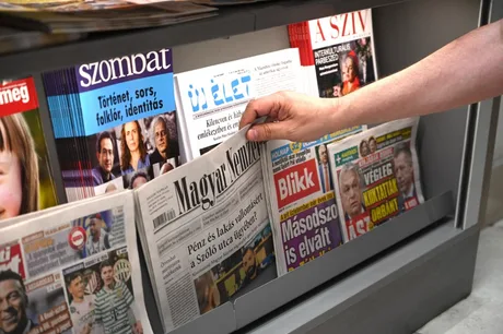 Ziare expuse pe un raft, reprezentând diversitatea mass-mediei din Ungaria.