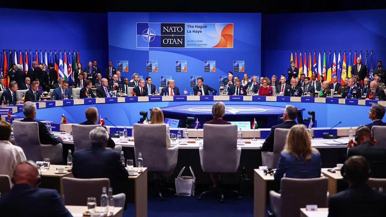 Reuniune NATO cu reprezentanți din diverse țări, discutând despre finanțarea apărării.
